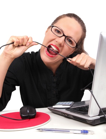Businesswoman bitting a cable, portrait on whiteの写真素材