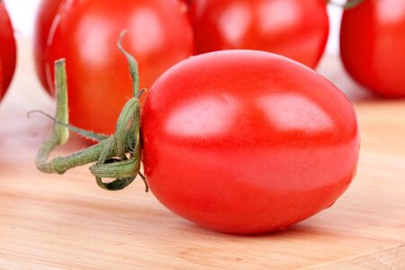 Tomato cherry branch on wooden board, macro shot の写真素材