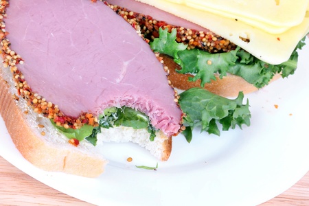Sandwich on white plate, closeup on wooden boardの写真素材