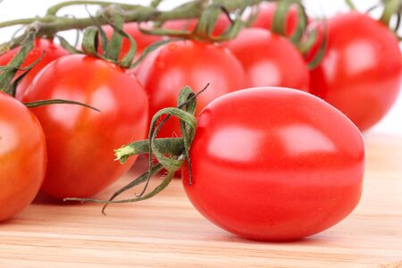 Tomato cherry branch on wooden board, closeup の写真素材