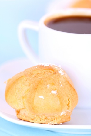 Cup of coffee and cake on blue tablecloth, closeupの写真素材