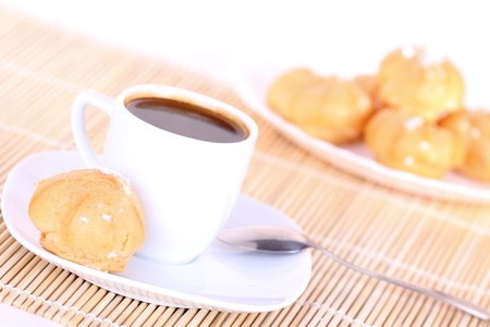 Cup of coffee and cakes on wooden mat, closeup on whiteの写真素材
