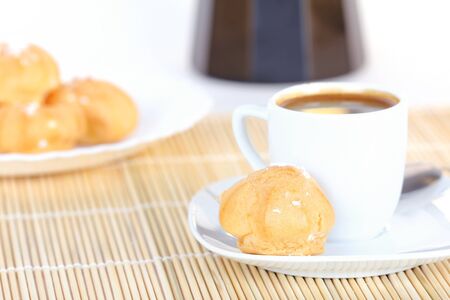 Cup of coffee and sweet cakes on wooden mat, closeupの写真素材