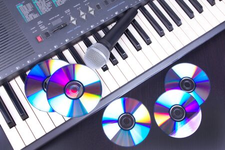 Vocal microphone,cd discs and electronic keyboard, Closedup on black table の写真素材