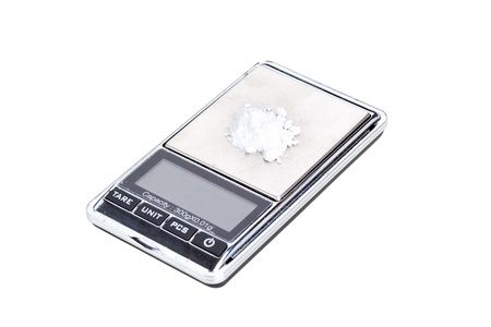Cocaine on digital scales, isolated on whiteの写真素材