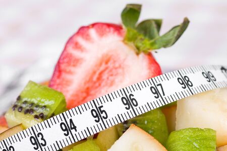 Fruit salad and strawberry with measure tape, close up の写真素材