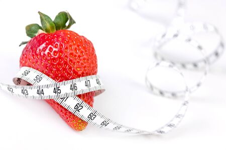 Strawberry with measure tape, closeup on white backgroundの写真素材