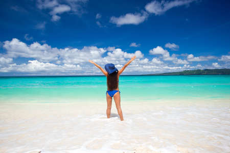 Happy woman on the beach with summer hatの写真素材