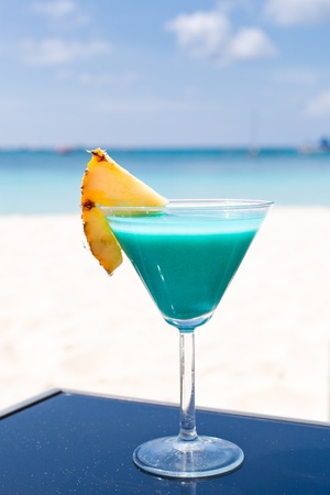 Blue Curacao cocktail with slice of ananas on white beachの写真素材