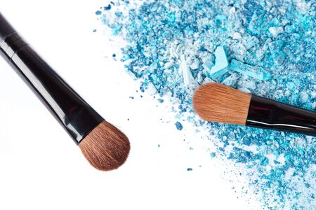 Crumbled eyeshadow with brush, closeup on whiteの写真素材