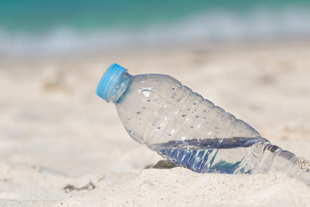 Water in bottle on sand on tropical beach