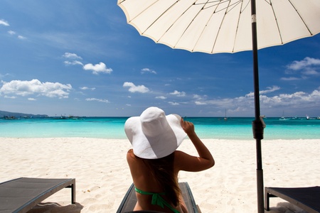 Woman in color hat sitting in chaise longueの写真素材