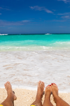 Male and female legs on tropical beach, closeupの写真素材