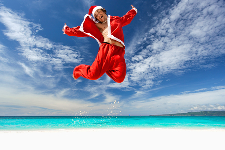 Santa Claus jumping on beachの写真素材
