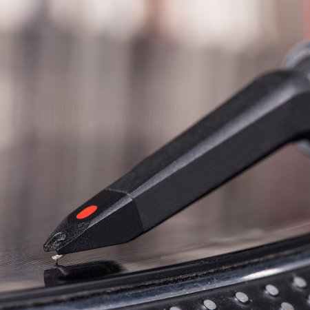 Dj needle stylus on spinning record, vinyl background
