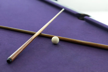 Billiard cues and white ball in pool table
