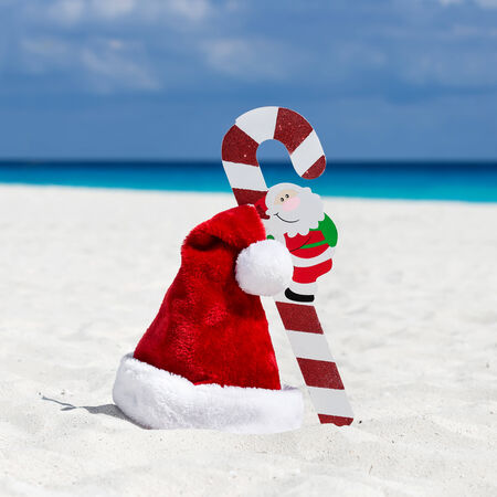 Santa Claus hat and cane at caribbean sandy beach, Cancun. Holiday conceptの写真素材