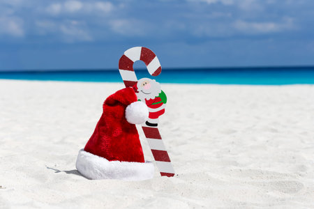 Santa Claus hat and cane at caribbean sandy beach, Cancun. Holiday conceptの写真素材