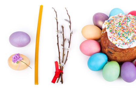 Easter cake, painted eggs and church candle closeup on white background