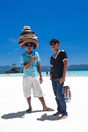PHILIPPINES, BORACAY ISLAND - 20 MARCH 2013: Beach sellers of sunglasses and sun hats on coastlineのeditorial素材