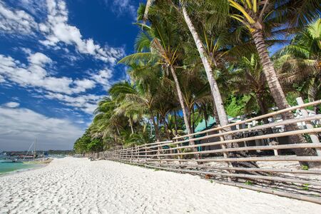 Bamboo fence on tropical beachの写真素材