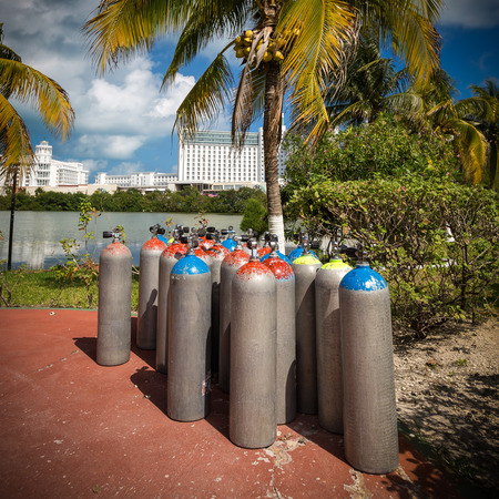 Scuba air tanks outdoors near palm treeの写真素材
