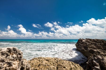 Ocean with waves and rocks on caribbean beachの写真素材