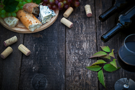 Wine bottles with grape leaves on wooden background with copy spaceの写真素材
