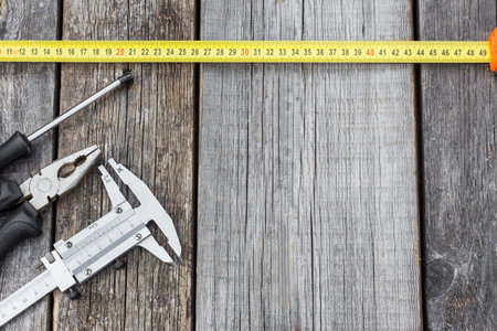 Different construction equipment on a wooden background with copy space