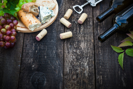 Wine bottles with grape leaves on wooden background with copy space, selective focusの写真素材
