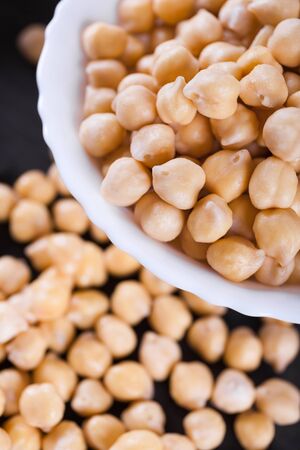 Raw wet gold chickpeas on wooden board, healthy vegan food with a lot protein, macro shot, selective focusの写真素材