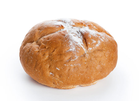 Homemade whole round bread sprinkled with flour closeup on white background