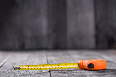 Measuring tape on a wooden board with copyspaceの写真素材