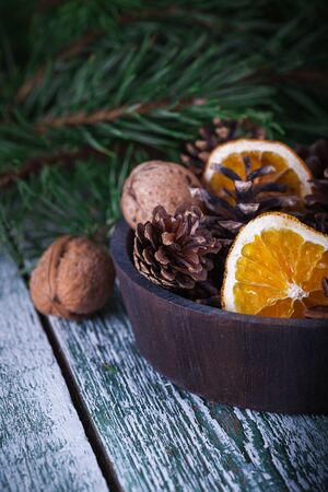 Christmas decoration card with evergreen fir tree, cones, cinnamon on rustic wooden background. Selective focus, shallow dofの写真素材