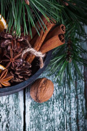 Christmas decoration card with evergreen fir tree, cones, cinnamon on rustic wooden background. Selective focus, shallow dofの写真素材