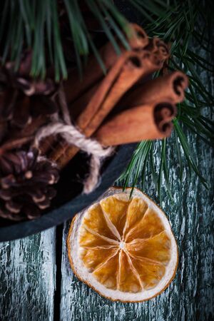 Christmas decoration card with evergreen fir tree, cones, cinnamon on rustic wooden background. Selective focus, shallow dofの写真素材