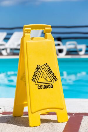 Wet floor warning sign near a swimming poolの写真素材