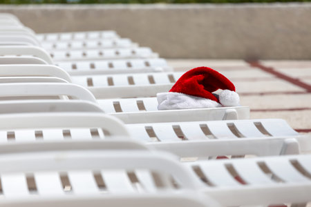 Santa Claus Hat on sunbed near swimming pool. Christmas vacation conceptの写真素材