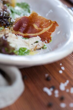 Beef carpaccio in lettuce salad on wooden tableの写真素材