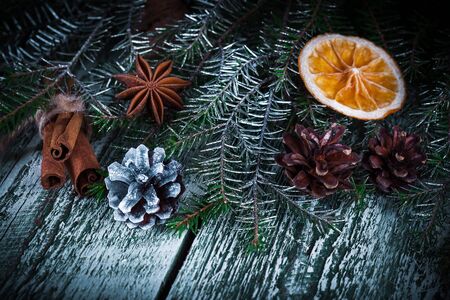 Christmas decoration card with evergreen fir tree, cones, cinnamon on rustic wooden background. Selective focus, shallow dofの写真素材