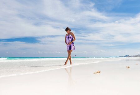 Beautiful pregnant woman walking on perfect white beachの写真素材