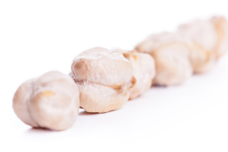Align raw dry chickpeas on white background, healthy vegan food with a lot of proteinの写真素材