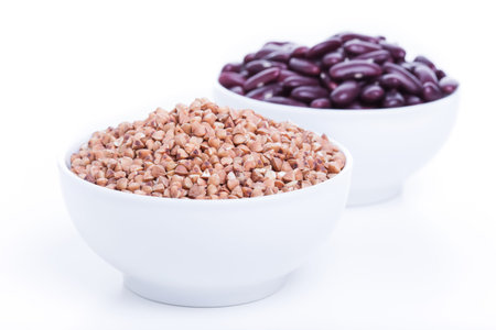Dry buckwheat and black beans in white bowl, source of Iron (Fe)