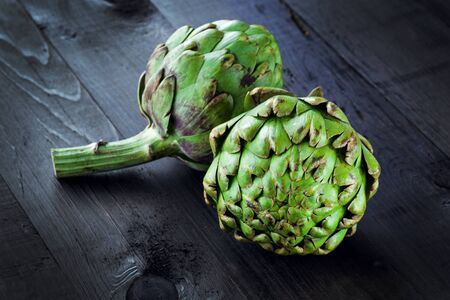 Fresh green artichokes on wooden boardの写真素材