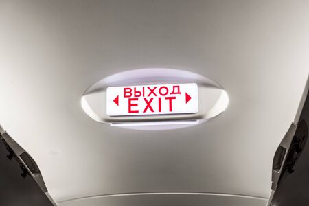 Exit sign on overhead in passenger airplaneの写真素材