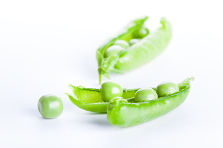 Open green pea pod isolated on white backgroundの写真素材