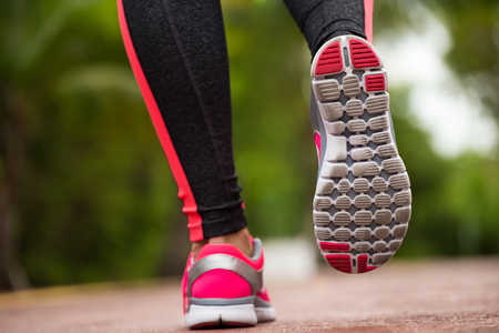 Fitness woman training and jogging in summer park, close up on running shoes. Healthy lifestyle and sport conceptの写真素材