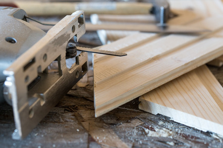 Fretsaw, hammer, knife and tongue and groove boards on working place, closeupの写真素材