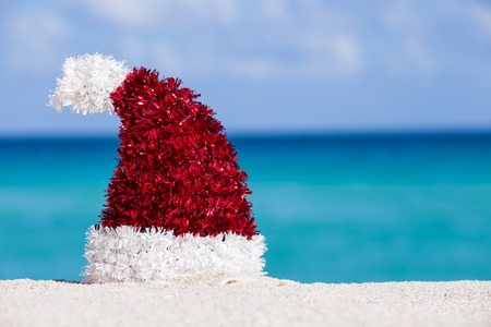 Santa Hat at white sandy beach on Caribbean sea backgroundの写真素材