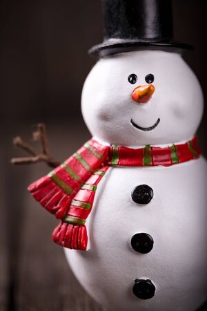Snowman toy on rustic wooden background. Christmas and New Year celebrationの写真素材
